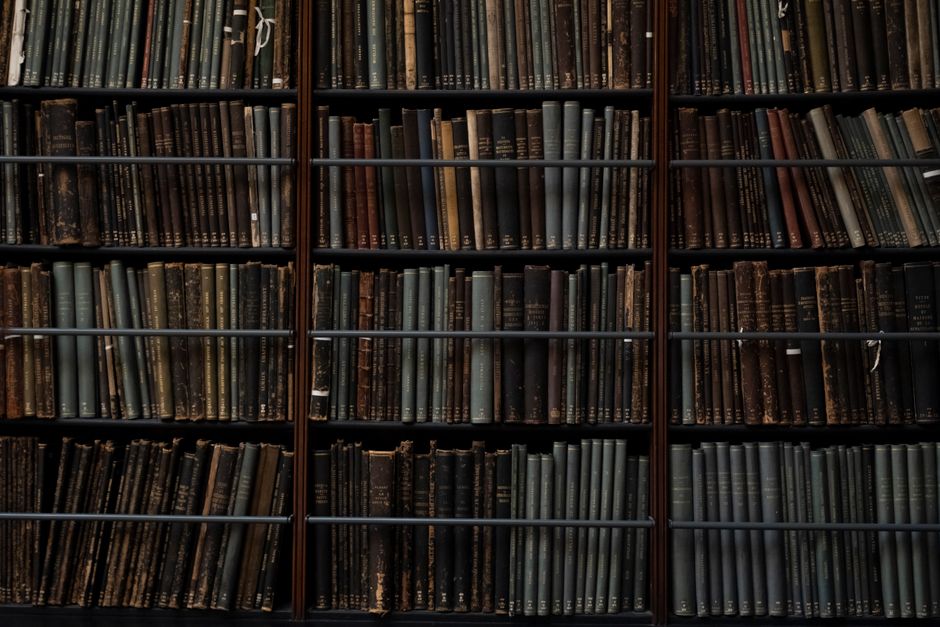Stare książki na półkach w bibliotece